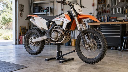 Dirt bike supported on a mechanical lift stand in a home workshop