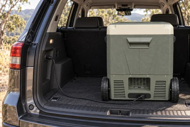 Eisberge fridge connected to a parked vehicle’s DC outlet with a car power lead.